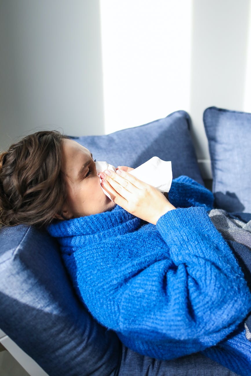 woman in blue sweater lying on bed